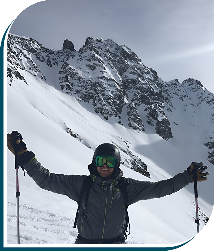 A man standing on top of a snow covered slope.